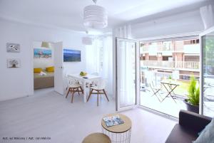 sala de estar blanca con mesa y balcón en Emma Apartment Central en Valencia