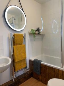 a bathroom with a tub and a sink and a mirror at HOLLINS NOOK - Countryside House - Gateway to Lakes National Park in Burneside +33 photos