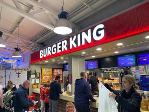 un grupo de personas de pie en una tienda de hamburguesas King en Modern & Homley 3BR Caravan, en Hastings