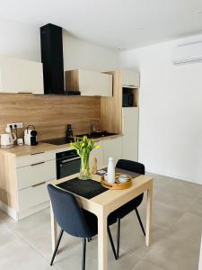 a kitchen with a table and two chairs and a table at Appartement centre de Roanne 38m2 in Roanne