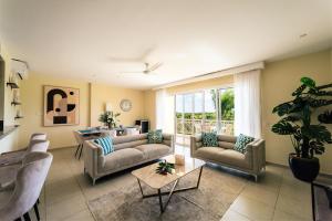 a living room with couches and a table at Apartment Almas Iberosta Bavaro 3BDR with Pool and Private Beach in Punta Cana
