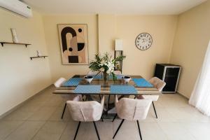 a dining room with a table and chairs and a clock at Apartment Almas Iberosta Bavaro 3BDR with Pool and Private Beach in Punta Cana