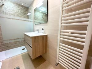 La salle de bains est pourvue d'un lavabo et d'un miroir. dans l'établissement Dos Torres Conde Aranda - Céntrico con estacionamiento Incluido, à Saragosse