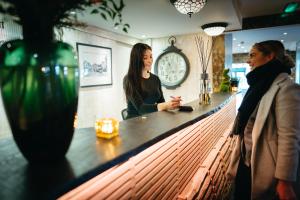 Due donne in piedi al bancone in un bar di The Inn At Grasmere a Grasmere