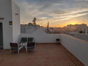 a balcony with two chairs and a table on a building at El Sardinero in Chipiona