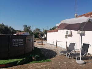 two chairs and an umbrella next to a building at Casa da Venda do Ferrador in Estremoz