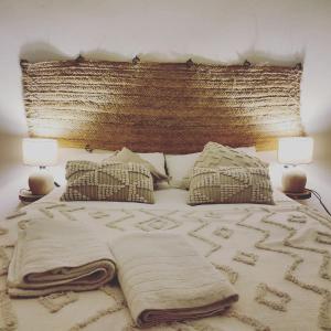 Una cama con una manta y dos lámparas. en Esencia Lodge - luxurious off-grid cabin retreat en Almuñécar