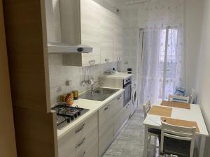 uma cozinha branca com um lavatório e um fogão em new home with garden em Nápoles
