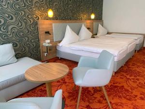 リューデスハイム・アム・ラインにあるホテル フェルセンケラーのベッド、テーブル、椅子が備わるホテルルームです。