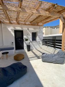 un patio con toldo y almohadas en el suelo en AVALON Luxury Suites, en Ermoupoli