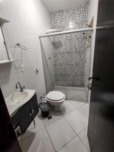 a bathroom with a shower and a toilet and a sink at Suite aconchegante em Cruzeiro in Cruzeiro
