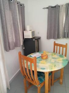 a dining room table with two chairs and a table with at La villa du cocotier in Sali Nianiaral +8 photos