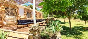 eine Terrasse eines Hauses mit einer schwarzen Couch in der Unterkunft Esencia Lodge - luxurious off-grid cabin retreat in Almuñécar