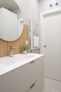 Baño blanco con lavabo y espejo en NUEVO Apartamento en el centro de Donosti, en San Sebastián