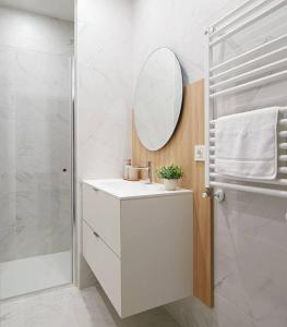 a white bathroom with a sink and a mirror at NUEVO Apartamento en el centro de Donosti in San Sebastián