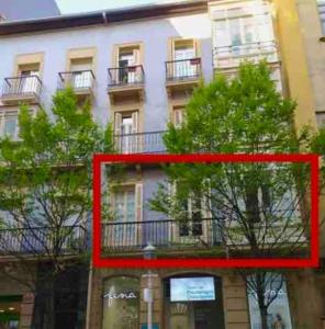 una imagen roja de un edificio con árboles delante de él en NUEVO Apartamento en el centro de Donosti, en San Sebastián