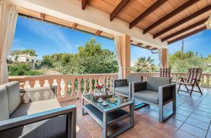 a patio with chairs and a table on a deck at Tacaritx de Bonaire, with pool and garden in Alcudia