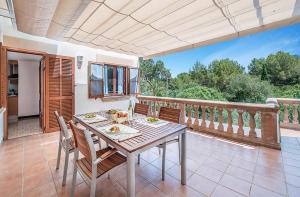 a dining room with a table and chairs on a balcony at Tacaritx de Bonaire, with pool and garden in Alcudia