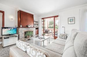 a living room with a couch and a tv at Tacaritx de Bonaire, with pool and garden in Alcudia