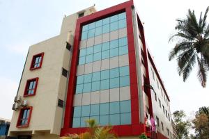 a red and white building with a palm tree at OYO Hotel Ganga Sagar Near Sri Someshwara Swami Temple in Bangalore