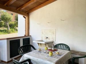 uma mesa com cadeiras e um lavatório no pátio em Casa Giovanni - Pomonte em Pomonte