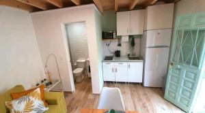 a small kitchen with a white refrigerator and a table at Casita de la playa in Rincón de la Victoria