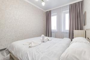 un lit blanc avec deux serviettes dessus dans l'établissement Жк Millennium Park,на Главной площади страны., à Astana