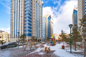 une aire de jeux dans une ville avec de grands bâtiments dans l'établissement Жк Millennium Park,на Главной площади страны., à Astana