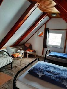 Cette chambre mansardée comprend 2 lits et une fenêtre. dans l'établissement Ferienhaus Schoene, à Hohnstein