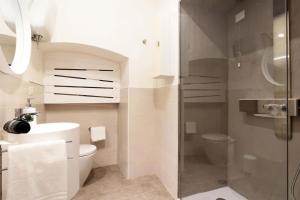 a bathroom with a toilet and a glass shower at Flat with whirlpool bath in the historic centre in Perugia