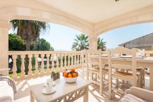 a porch with a table and chairs and a bowl of fruit at Countess Attic E at Alcudia Beach in Alcudia