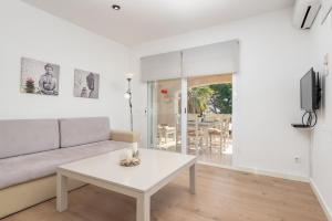 a living room with a couch and a table at Countess Attic E at Alcudia Beach in Alcudia