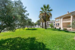 a park in front of a building with palm trees at Countess Attic E at Alcudia Beach in Alcudia