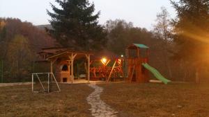 a playground with a slide and a play structure at Pensiunea Zece Brazi Cheia in Măneciu