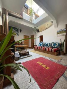 a living room with a couch and a red rug at SALAS waveclimbing company in Sidi Ifni