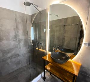 ein Badezimmer mit Waschbecken und Spiegel in der Unterkunft AVALON Luxury Suites in Ermoupoli