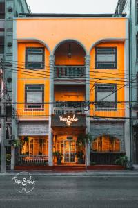 an orange building with a restaurant on a city street at Time Sabai 32 in Bangkok