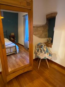 a mirror in a room with a bed and a chair at Il Ciapiné in Giaveno