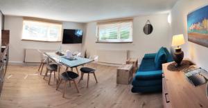 un salon avec une table et un canapé bleu dans l'établissement FeWo Heimathafen, à Bodman-Ludwigshafen 25 autres photos