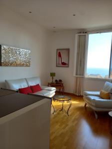 a living room with white furniture and a large window at Amazing view - Monaco in Cap d'Ail