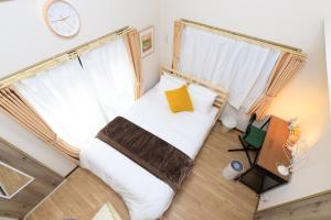 Un dormitorio con una cama y un reloj en la pared. en Rooms天神 02, en Fukuoka