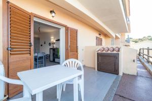 a white table and chairs on a patio with a refrigerator at Appartamento trilocale vista mare FT4 in Cascabraga