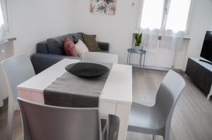 een woonkamer met een tafel en een bank bij Casa Nicho Salo' in Salò