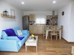 a living room with a blue couch and a table at Arbinfo Casa Rural in Guía de Isora