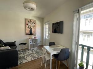 a living room with a white table and chairs at RETIRO 402 in Guimarães