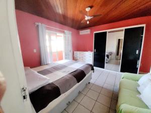 a bedroom with a large bed and a couch at Casa de praia / piscina in Santa Cruz Cabrália