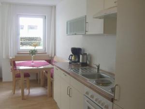 a kitchen with a sink and a table with a window at Berg-Juwel in Sankt Leonhard im Pitztal