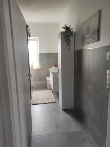 a bathroom with a toilet and a sink and a door at Ferienhaus Luna am schönen Harkebrügger See mit Kamin und Sauna in Barßel +12 photos