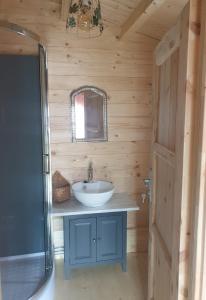 a bathroom with a sink in a wooden cabin at Le Cottage OneHeart in Saverne