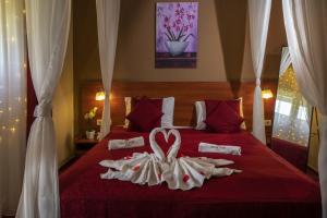 a hotel room with a red bed with a heart made out of towels at Patak Park Hotel Visegrád in Visegrád